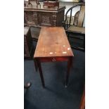 A mahogany Pembroke table with drawer to end resting on square supports.