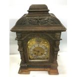 A 19th century carved oak cased bracket clock decorated with animal and male heads,