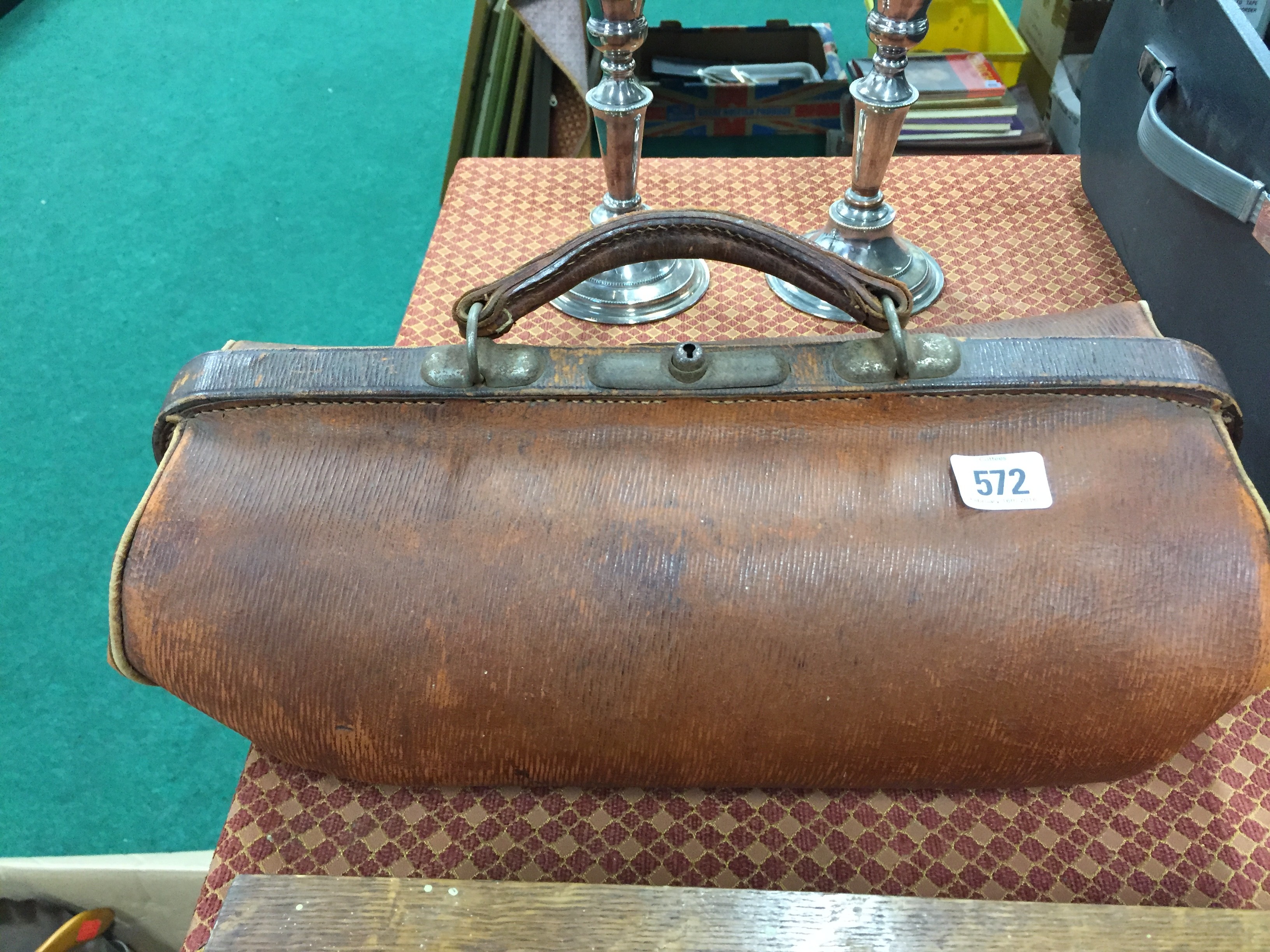 A brown leather Gladstone bag.