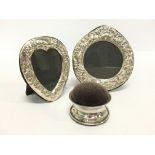 A small heart shaped silver photograph frame together with another and a silver pin cushion.
