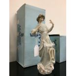 A Lladro china figure modelled as a young woman in long dress playing a harp (harp detached).