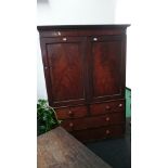 A large 19th century flame mahogany linen press with fitted interior.