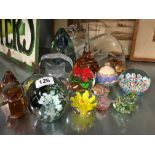 A collection of various glass paperweights.