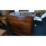 A large flame mahogany chest of drawers with box wood stringing and fluted corners on outswept feet.