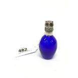 A blue glass scent bottle with silver Owl shaped lid.