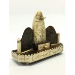 A Scrimshaw watch stand with central whales tooth, decorated with a Schooner,