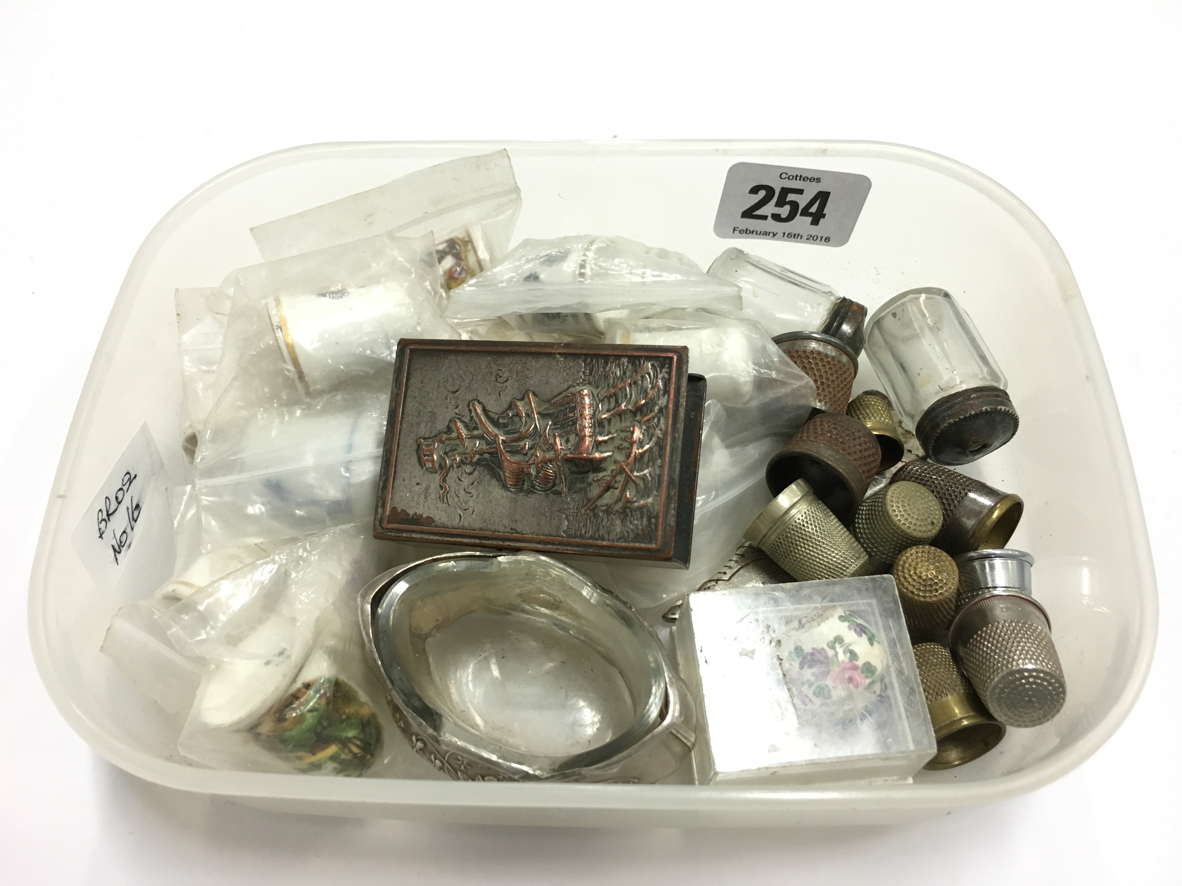 A carton containing various thimbles and other items.