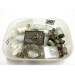 A carton containing various thimbles and other items.