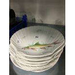 A set of eight Limoges porcelain scallop shaped fish plates.