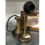 A brass candlestick telephone handset.