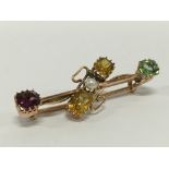 An antique yellow metal brooch set with various gemstones and a pearl.