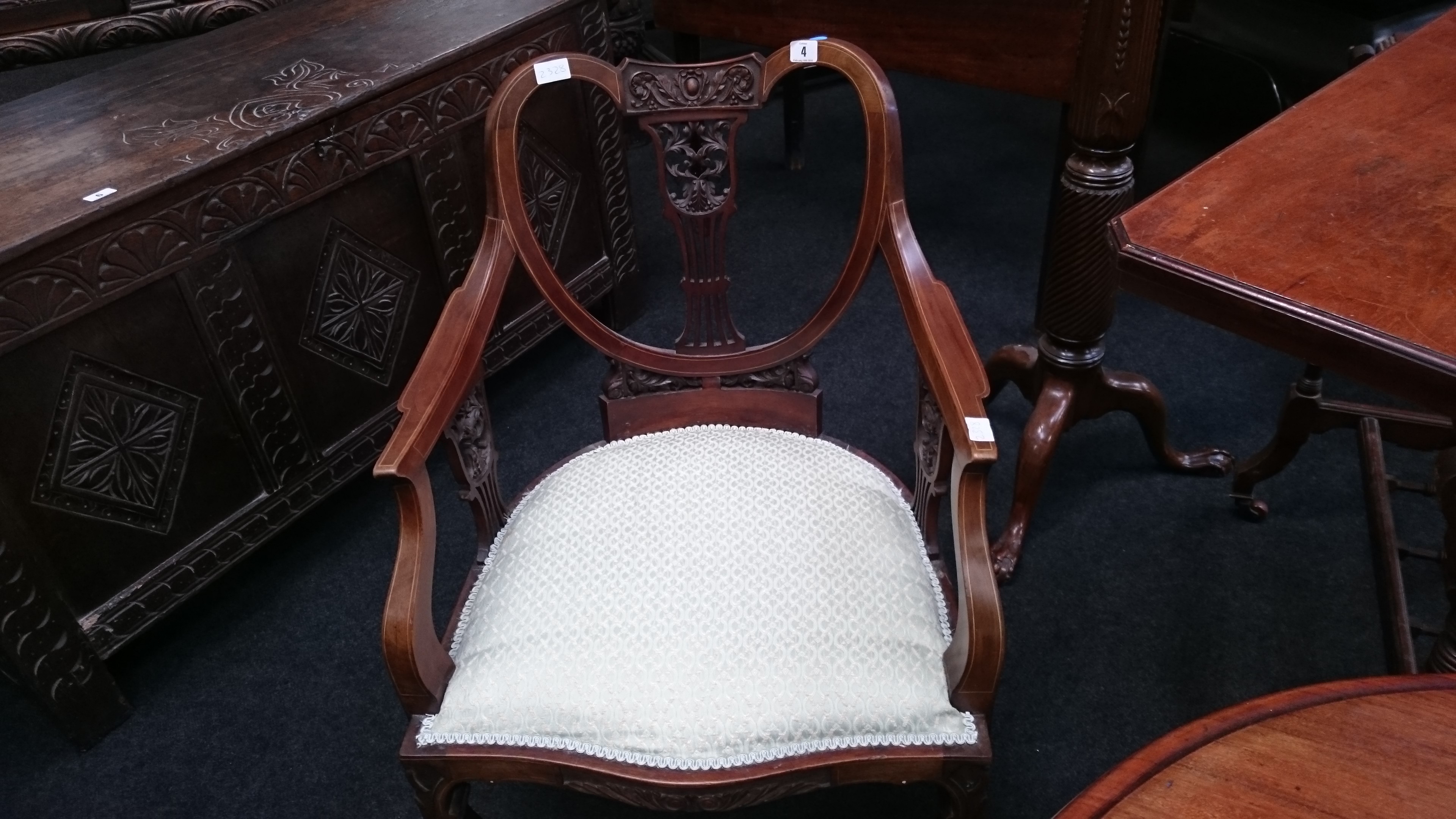 A satinwood inlaid bedroom chair with carved back rest and upholstered seat.