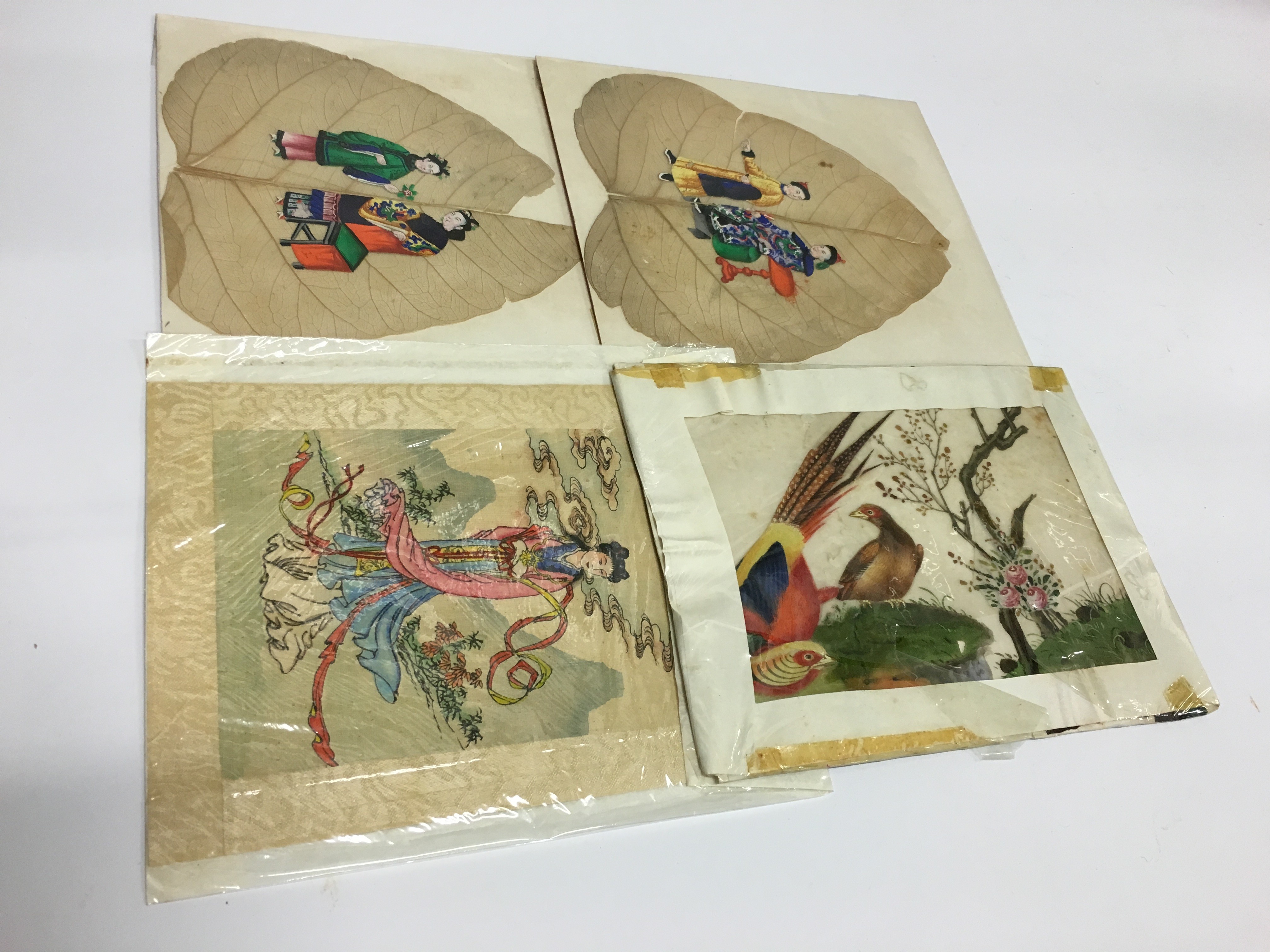 Four various Oriental silk and leaf paintings.