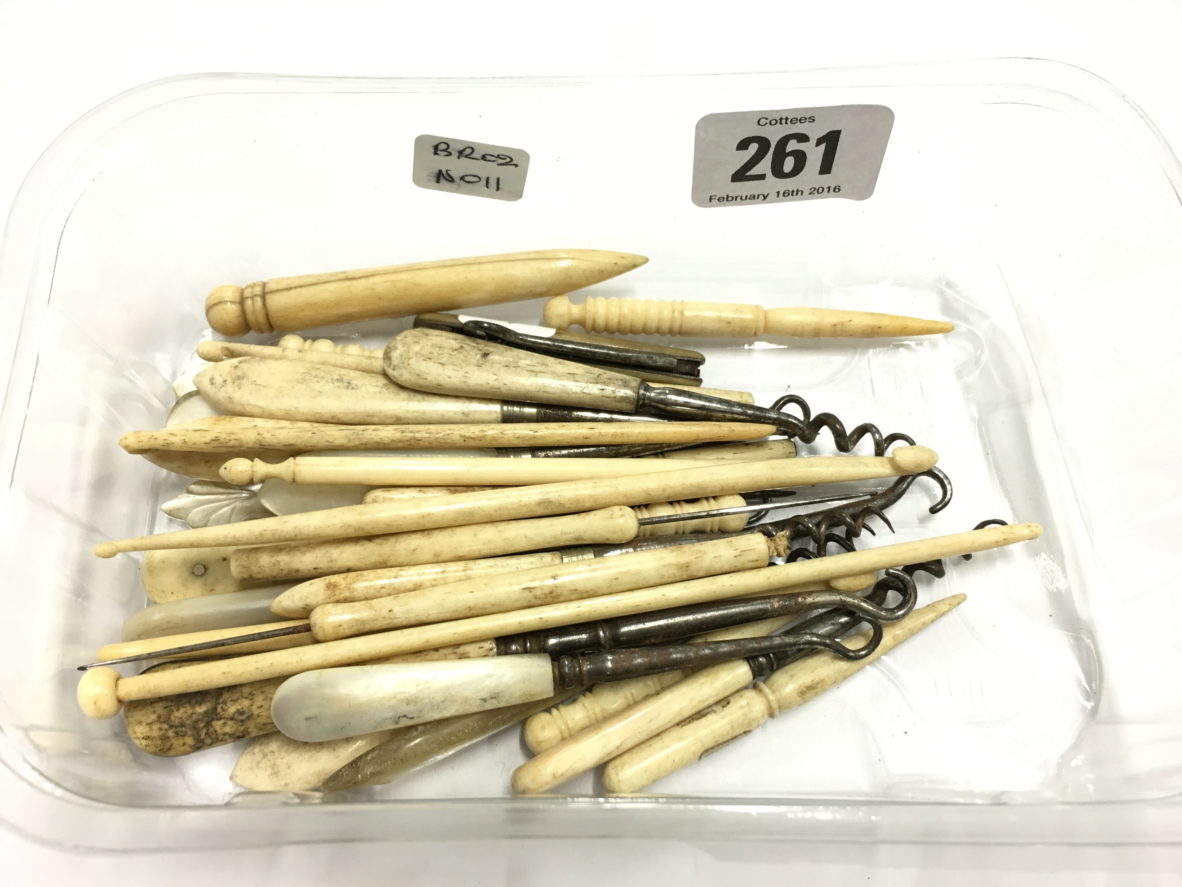 A carton containing various early 20th century ivory button hooks and similar items.