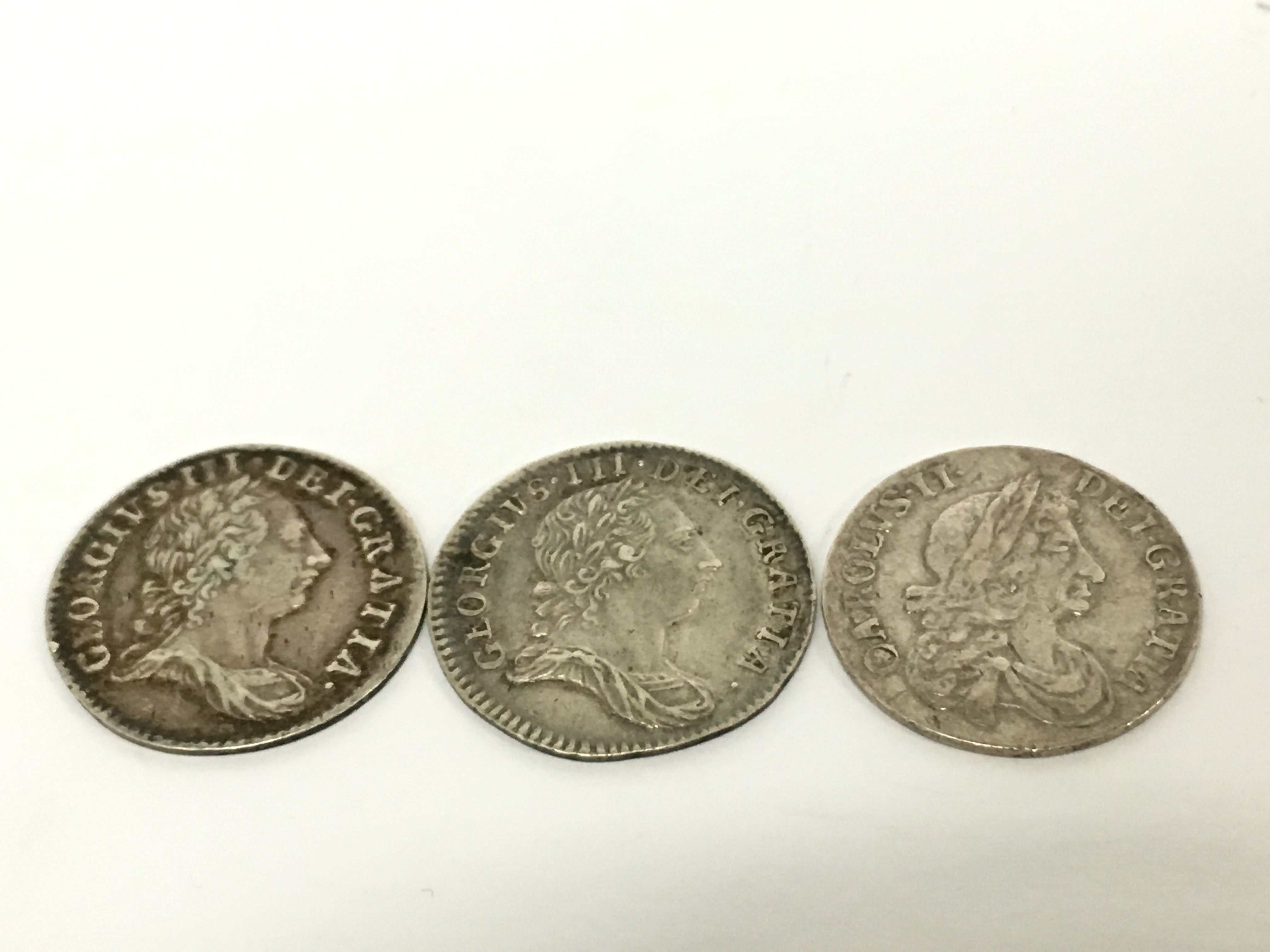 A 1763 silver 3d coin together with two other Georgian silver coins.