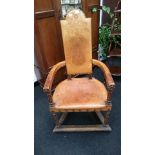 An Arts and Crafts style tooled leather ceremonial chair with open arms,