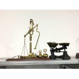 A pair of brass balance scales and bell weights together with another pair of scales.