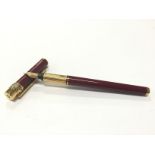 A Cartier Trilogy burgundy bodied fountain pen with 18 carat gold nib (298).