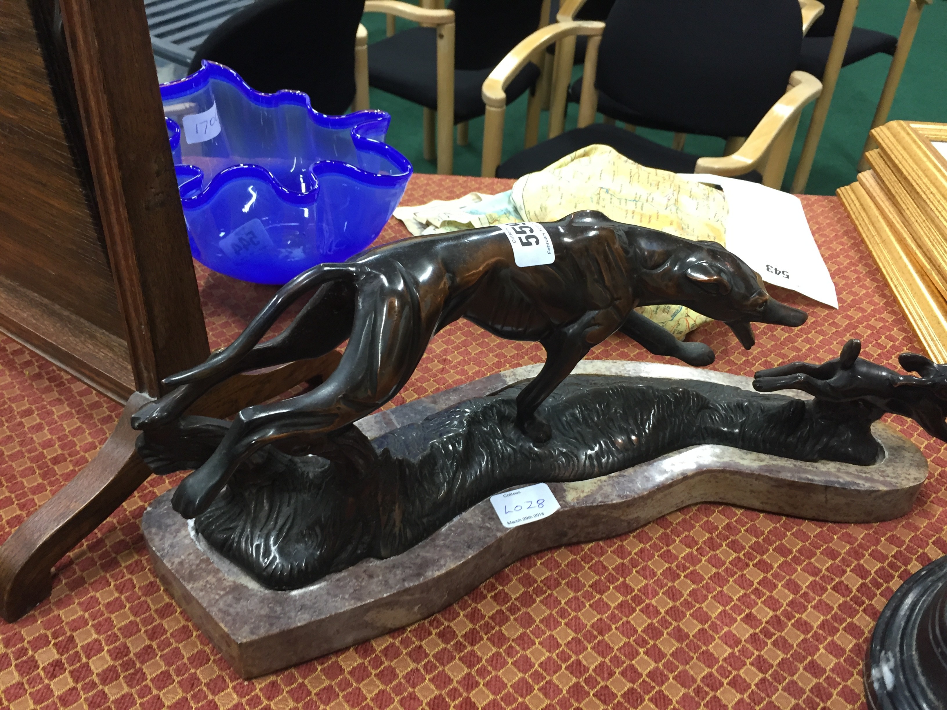 An Art Deco coppered bronze model of a Greyhound chasing a rabbit on red marble shaped base.