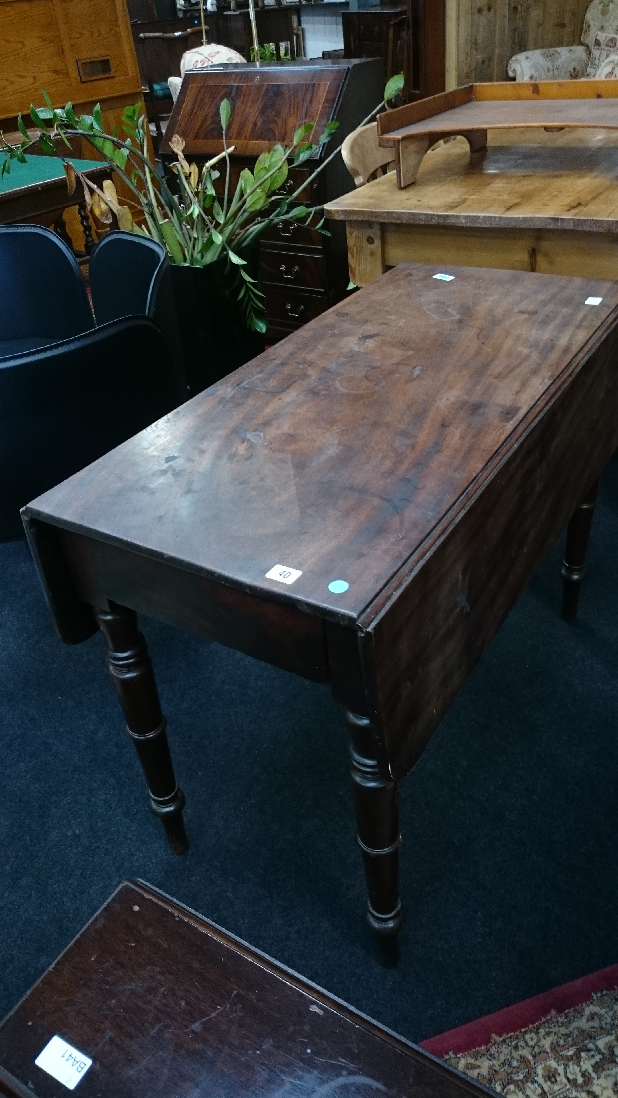 A mahogany Victorian Pembroke table resting on turned supports.