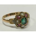 An antique 15 carat gold ring set with pearls and green and pink stones.