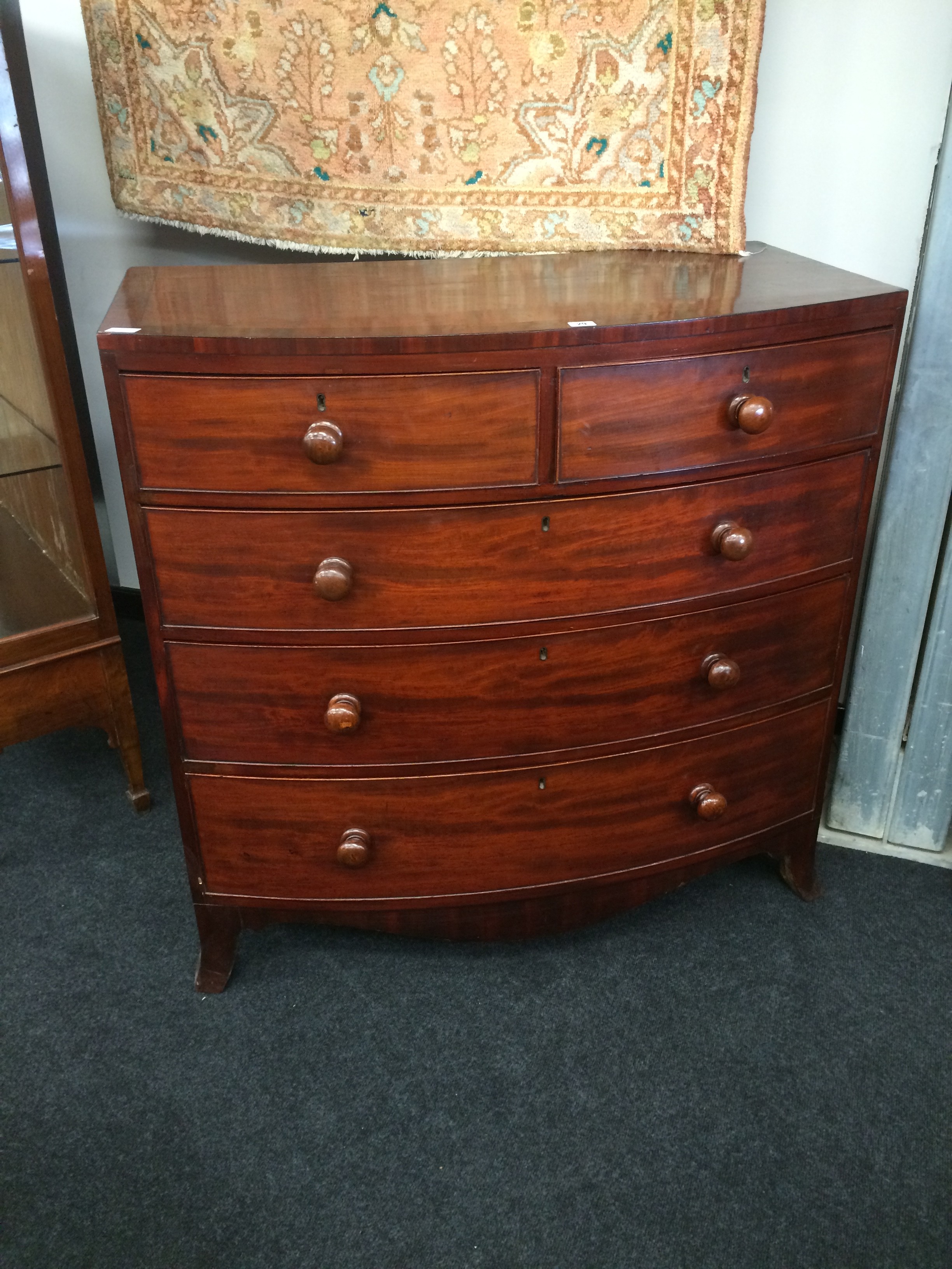 A Georgian mahogany bow front cross banded chest of two short and three long drawers resting on