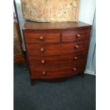 A Georgian mahogany bow front cross banded chest of two short and three long drawers resting on