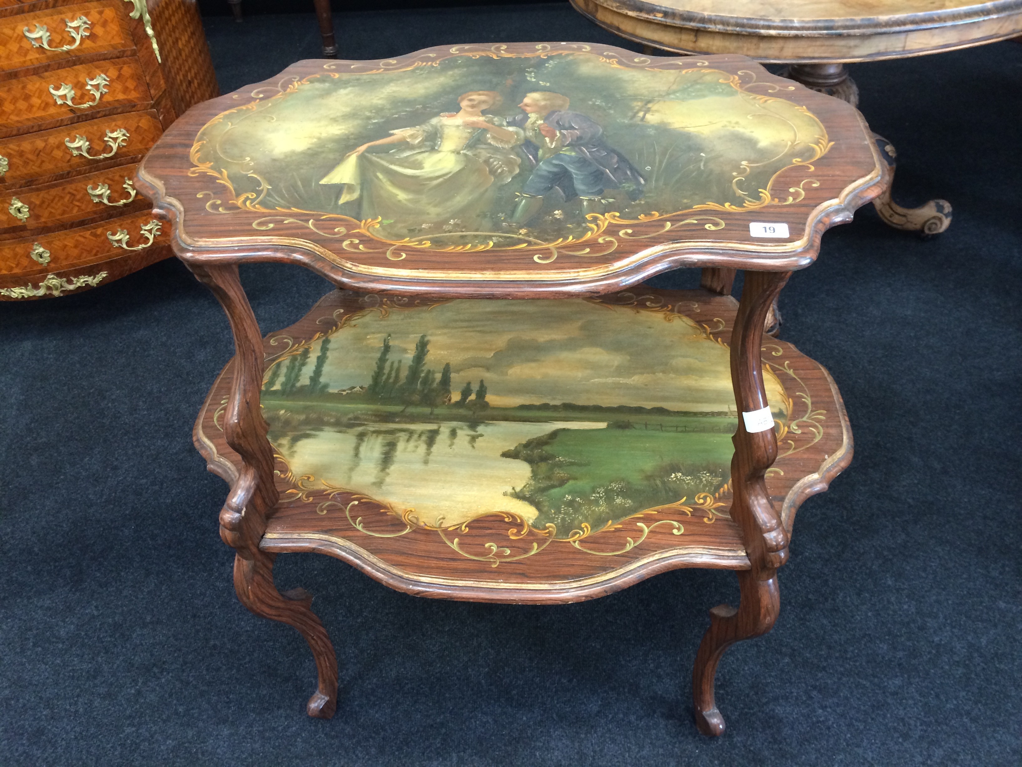 A late 19th century rosewood effect painted two tier tea table resting on shaped carved base,