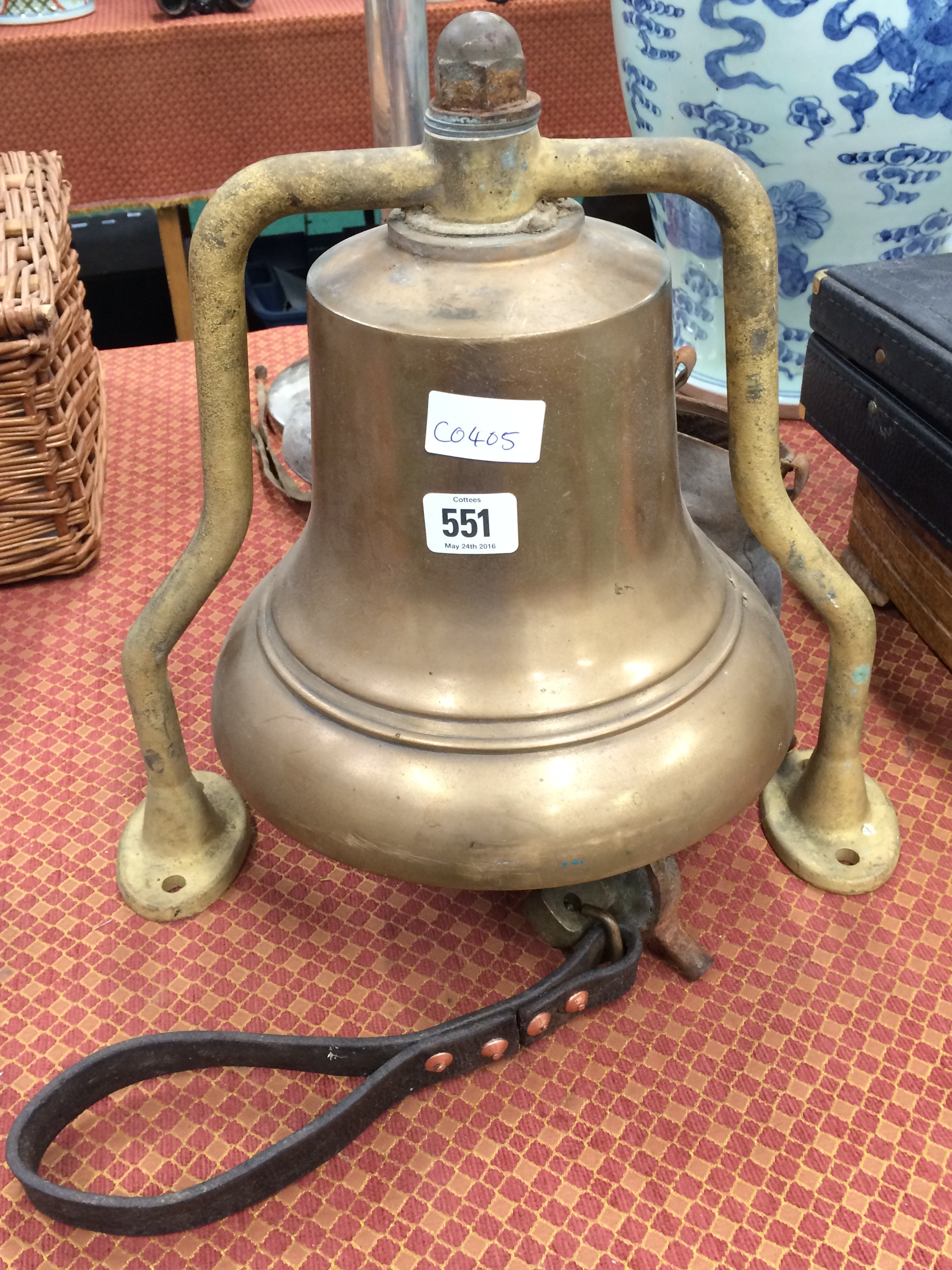 A heavy brass ships bell on metal stand.