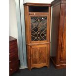 A Georgian chestnut and pine corner cupboard fitted with an astragal glazed top and panelled