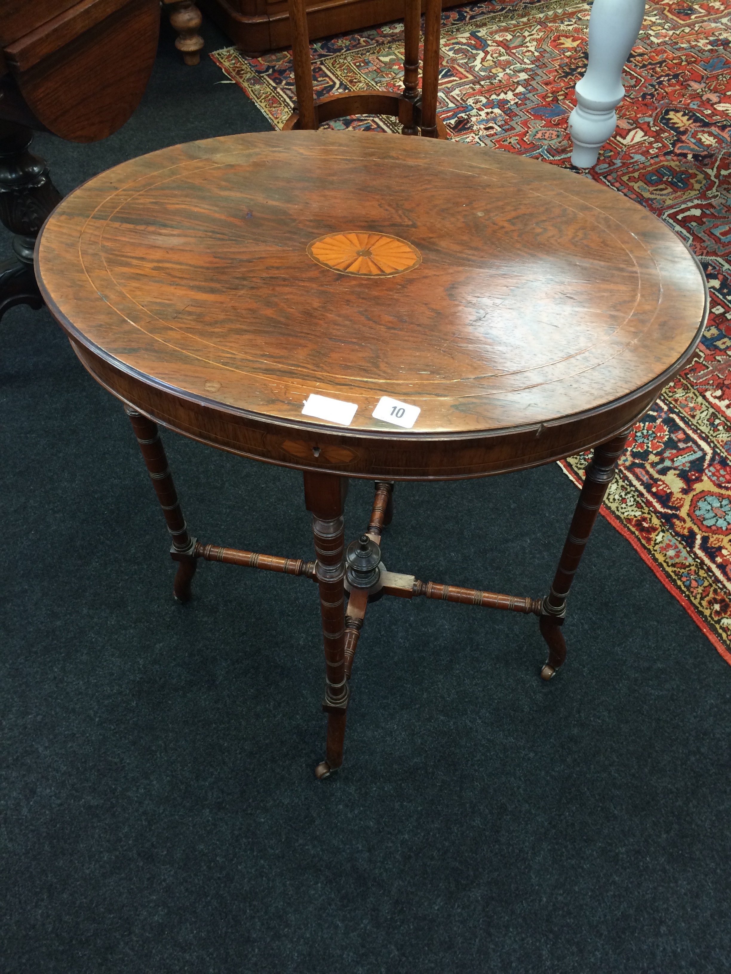 A Victorian rosewood and satinwood inlaid ladies work table resting on turned supports and castors.