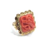 A 14ct gold Chinese Coral ring decorated with a flower with wavy gold mount, (9.