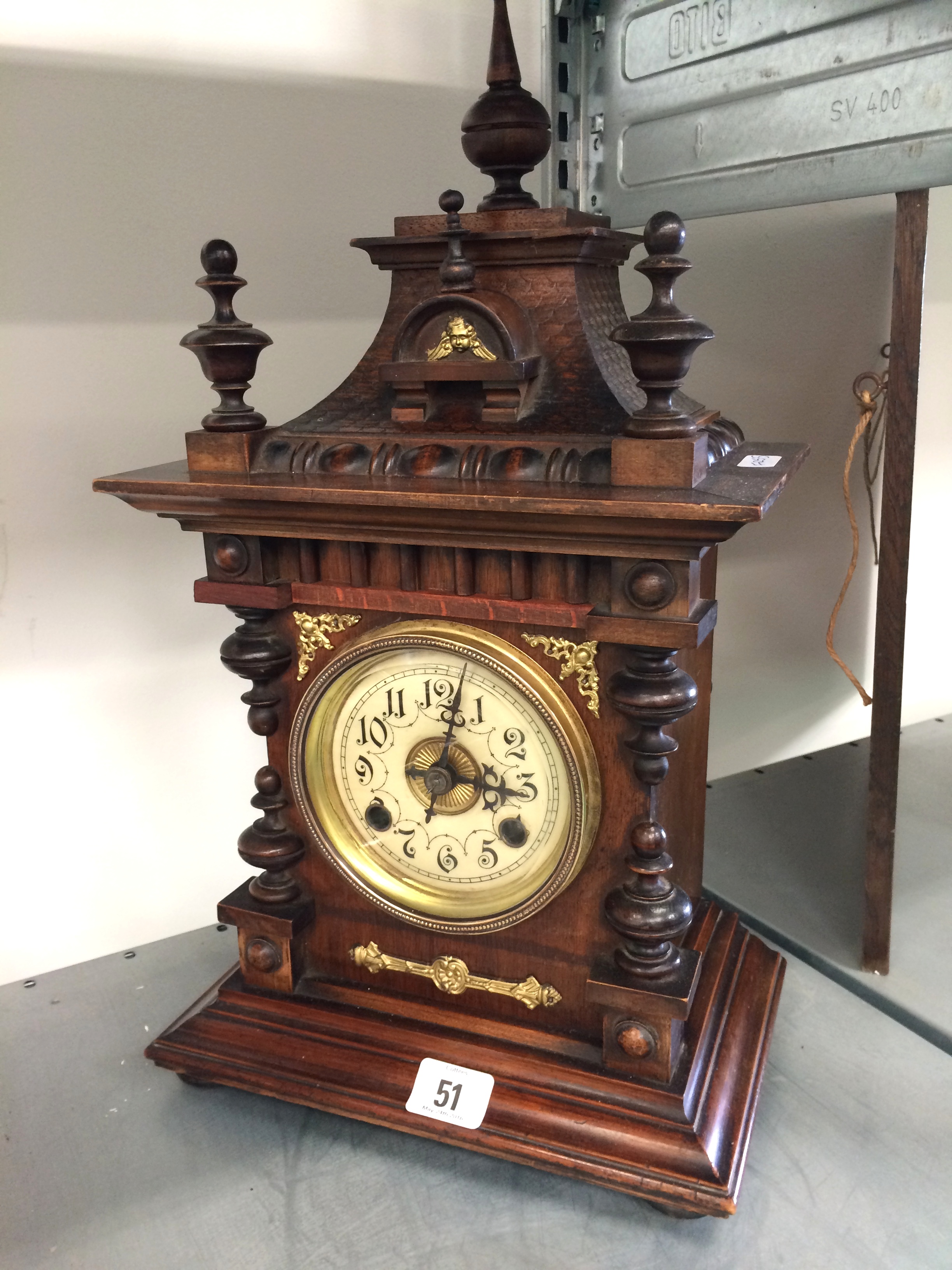 An oak cased Gothic style mantle clock with circular dial.