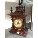 An oak cased Gothic style mantle clock with circular dial.