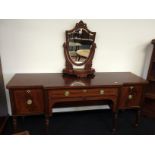 A George III mahogany breakfront sideboard with centre dummy frieze drawer and cellaret drawer with