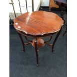 A Victorian mahogany shaped top occasional table resting on carved outswept legs and jardiniere