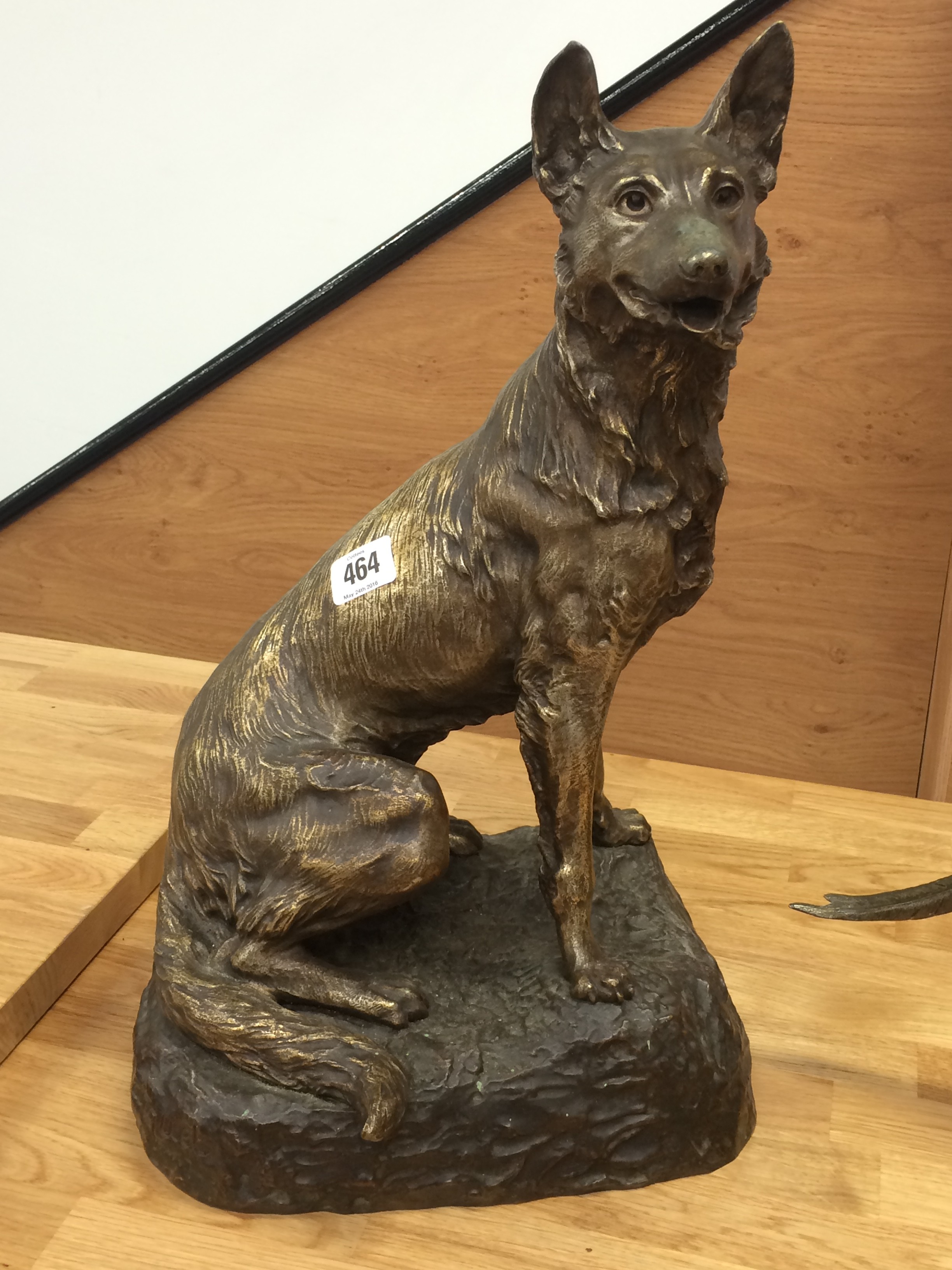 A French silvered bronzed study of a seated Alsatian on a rocky pedestal, signed R.