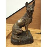 A French silvered bronzed study of a seated Alsatian on a rocky pedestal, signed R.