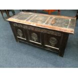 An antique oak carved front three panelled coffer.