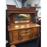 A late Victorian ash sideboard with fitted mirrored back, carved side panels, turned side columns,