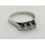 An 18 carat white gold three stone diamond ring (size L).