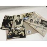 A facsimile signed Beatles black and white publicity photograph and four souvenir Beatles postcards.