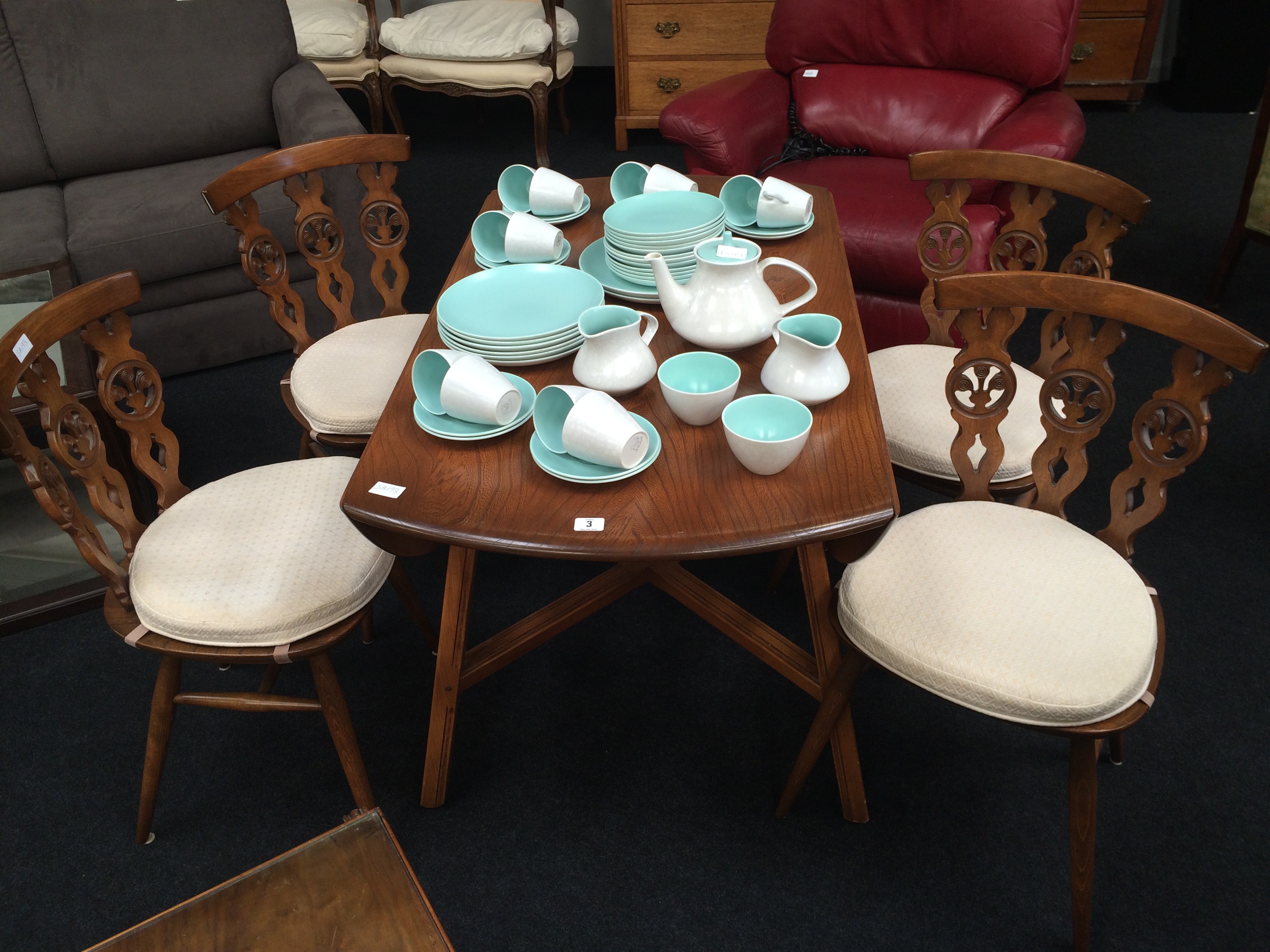 An Ercol drop leaf dining table resting on cross stretcher and square supports together with a set