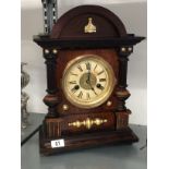 An oak cased mantle clock with circular dial, Roman Numerals.