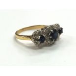 An 18 carat gold three stone sapphire and diamond set dress ring.