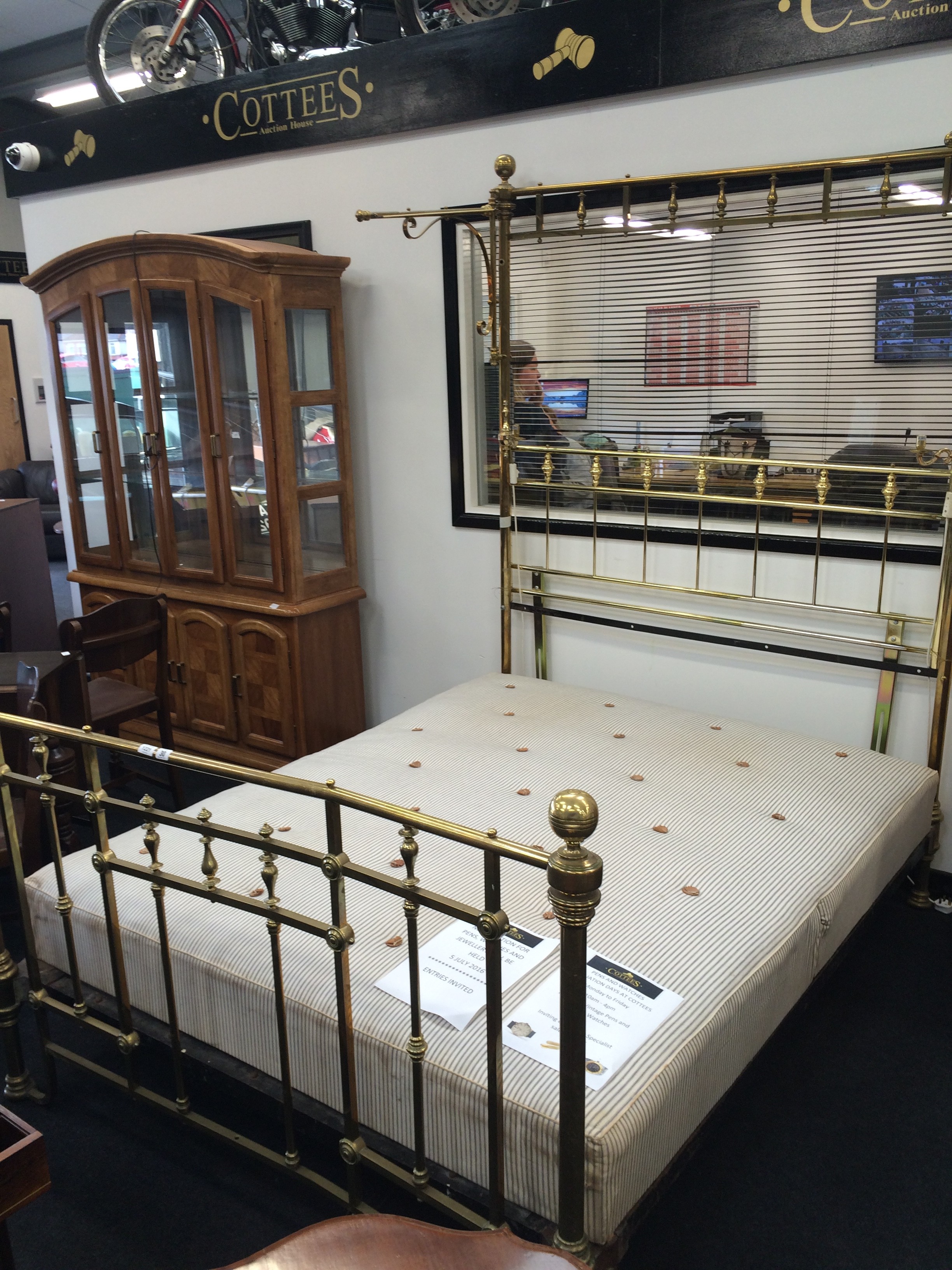 A large Victorian brass quarter canopy bed to include cast iron frame and mattress.