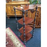 A Victorian mahogany four tier what-not resting on turned supports.