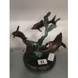 A Bronze sculpture decorated with dolphins on circular marble base.