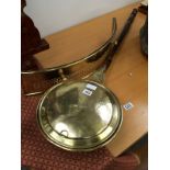 A brass bed warmer with turned wooden handle together with a pierced brass grate front.