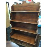 A French mahogany four tier buffet with scroll carved back fitted two drawers, brass knobs below,